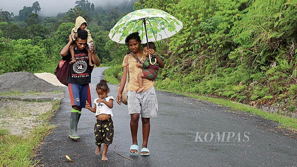 Ledi Lamanepa (20) bersama suami dan tiga anaknya berjalan kaki dari Desa Piliana, Kecamatan Tehoru, Kabupaten Maluku Tengah, Maluku, menuju kebun, Minggu (4/11/2018). 