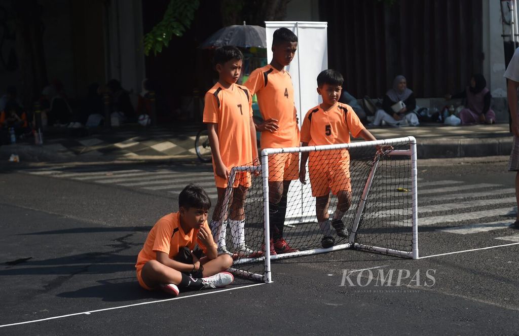 Pemain menunggu jadwal pertandingan di belakang gawang saat <i>street soccer </i>di Jalan Tunjungan, Surabaya, Jawa Timur, Minggu (8/10/2023). 