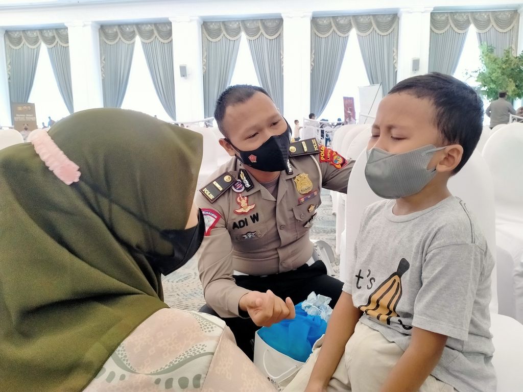 Seorang polisi membujuk anak agar mau mengikuti program vaksinasi Covid-19 di Bandar Lampung, Lampung, Selasa (11/1/2022). Vaksinasi Covid-19 untuk anak dinilai penting untuk mencegah risiko penularan virus saat pembelajaran tatap muka di sekolah.