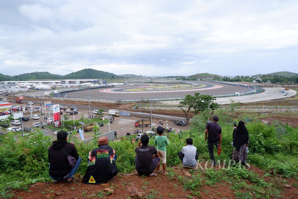 Warga menaiki bukit untuk menonton langsung  tes pramusim MotoGP di Sirkuit Internasional Jalan Raya Pertamina Mandalika, Kuta, Pujut, Lombok Tengah, Nusa Tenggara Barat, Jumat (11/2/2022). 