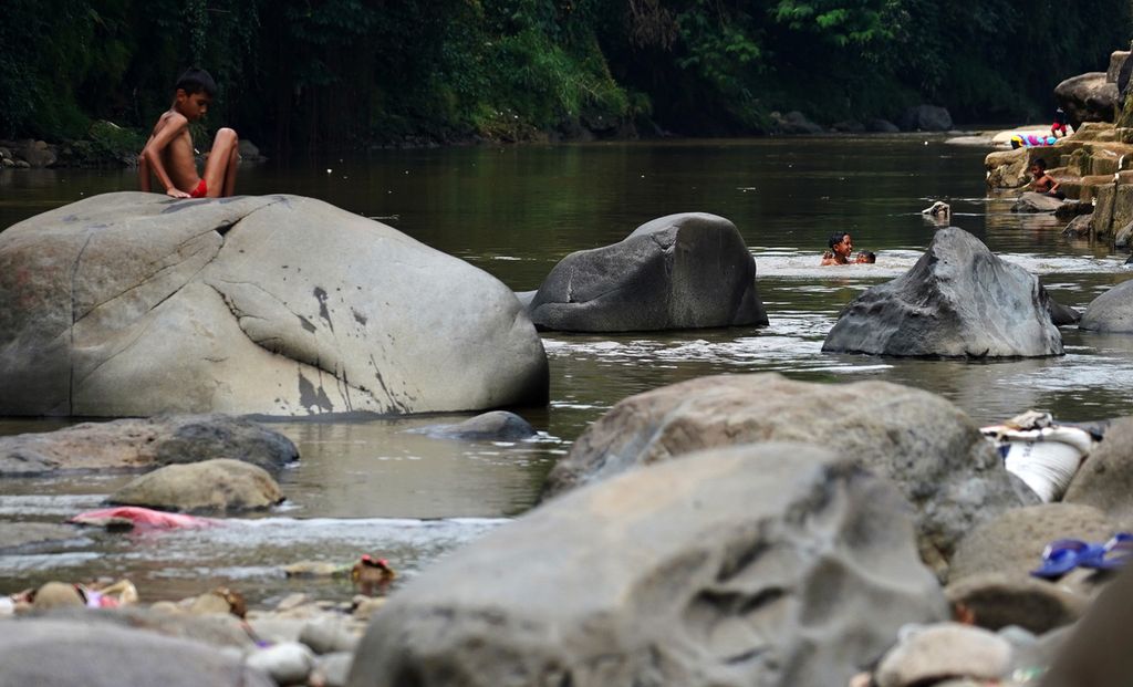 Sejumlah anak-anak bermain di aliran Sungai Ciliwung yang melintasi Pulo Geulis, Kota Bogor, Jawa Barat, Kamis (3/6/2021). Aliran Sungai Ciliwung menjadi salah satu ruang publik bagi keseharian warga di pemukiman padat setempat. 