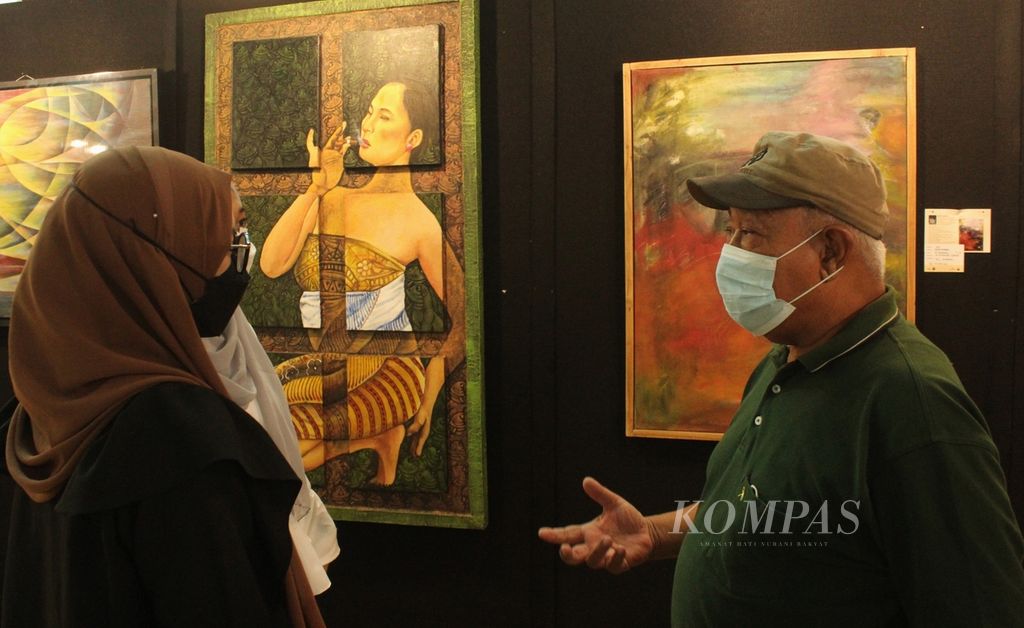 Perupa Eddy Kamal (kanan) berbincang dengan pengunjung dalam Pameran Seni Rupa Remaja Jakarta Era 70/80-an di Lobi Teater Kecil, Taman Ismail Marzuki, Jakarta, Rabu (15/6/2022). Pameran yang diikuti puluhan perupa tersebut berlangsung pada 8-16 Juni 2022. 