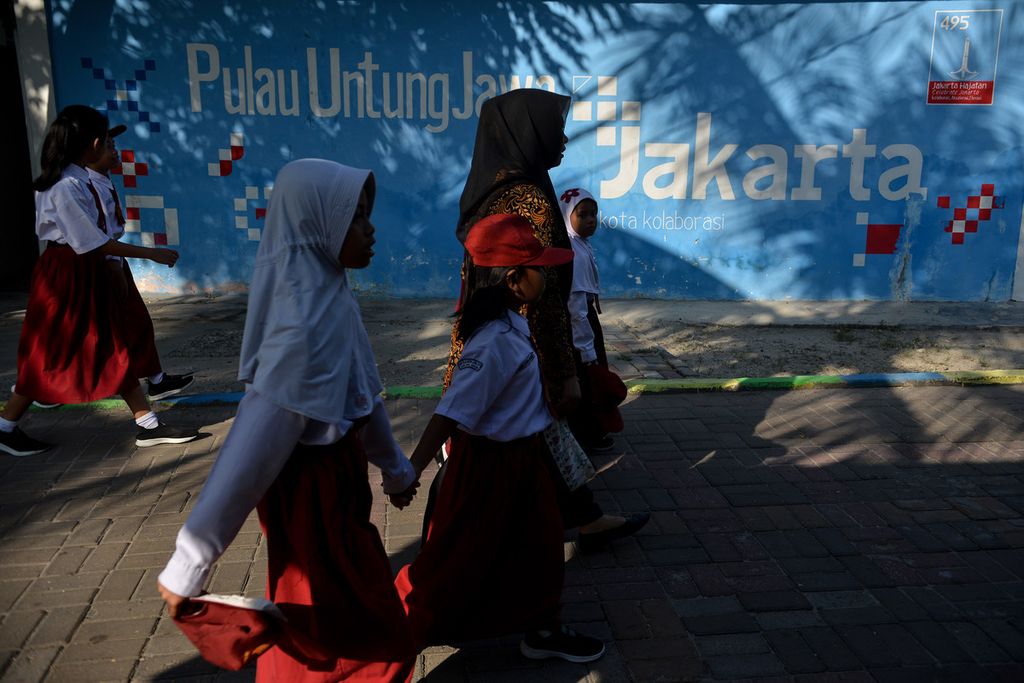 Para siswa bersama seorang guru berjalan di Pulau Untung Jawa, Kepulauan Seribu, Jakarta, Senin (15/5/2023).