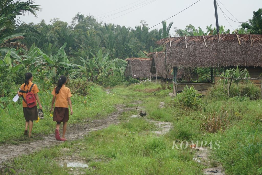 Anak-anak sekolah dasar berjalan menyusuri jalan trans-Mentawai yang baru dibuka di Dusun Buttui, Desa Madobag, menuju SD 24 Madobag, Kecamatan Siberut Selatan, Kepulauan Mentawai, Sumatera Barat, akhir Juli 2022.