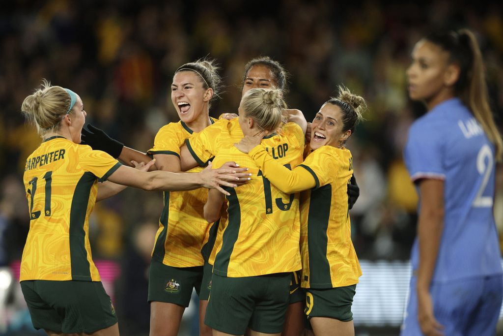 Pesepak bola putri Australia, Mary Flower (tengah, tidak tampak), dikerubuti rekan setimnya setelah mencetak gol dalam pertandingan persahabatan melawan Perancis di Melbourne, Australia, Jumat (14/7/2023). 