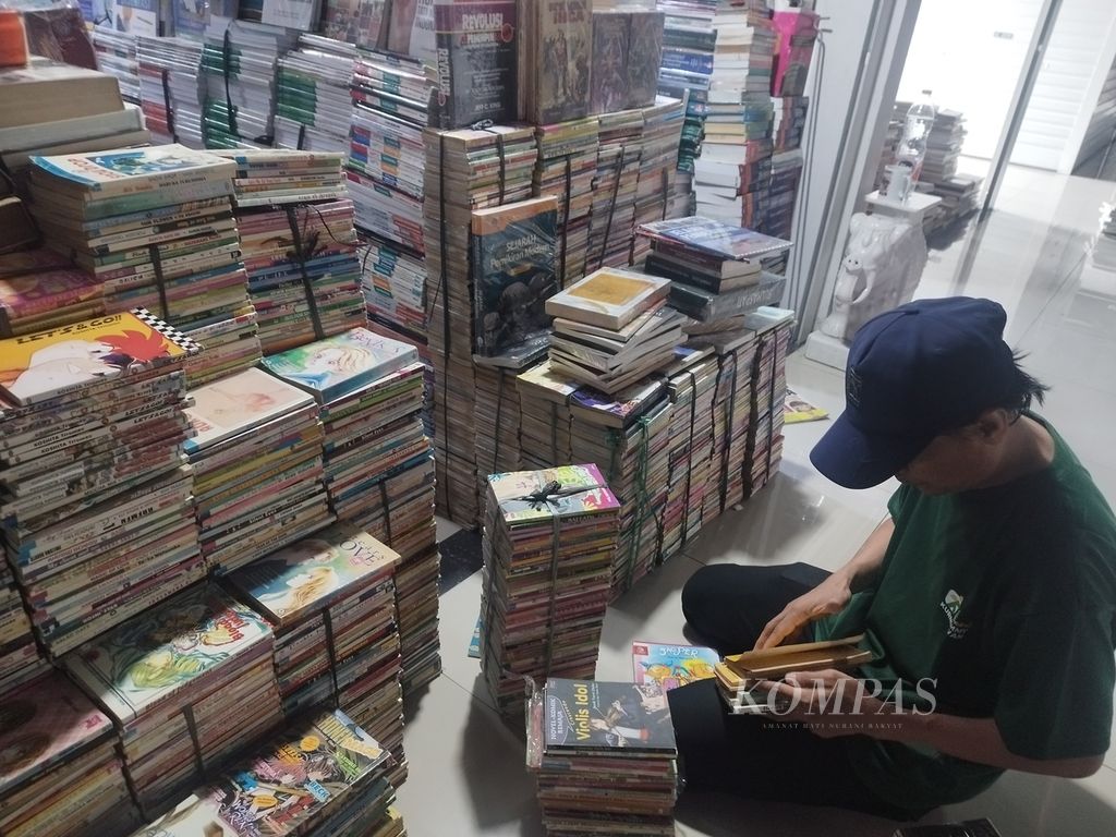 Pedagang tengah merapikan buku-buku di kiosnya yang berlokasi di Jakbook Pasar Buku Kenari, Kecamatan Senen, Jakarta Pusat, Selasa (20/12/2023).