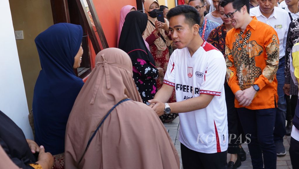 Wali Kota Surakarta Gibran Rakabuming Raka (baju putih) menyalami warga yang rumahnya baru saja dipugar, di Kelurahan Semanggi, Kota Surakarta, Jateng, Selasa (7/2/2023).