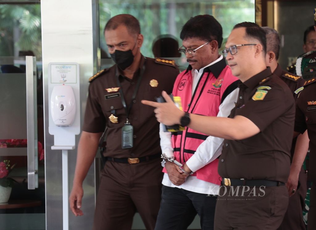Menteri Komunikasi dan Informatika Johnny G Plate (tengah) mengenakan rompi khusus saat ditahan usai diperiksa di Gedung Bundar Kejaksaan Agung, Jakarta, Rabu (17/5/2023). 