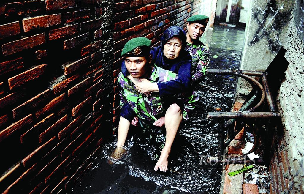 Prajurit Kostrad TNI AD mengevakuasi warga korban banjir yang sakit di Penjaringan, Pluit, Jakarta Utara, Selasa, 22 Januari 2013. Banjir besar pun tak menyurutkan sebagian besar warga tetap tinggal di rumah mereka. Partikel <i>pun</i> dalam kalimat tersebut bermakna ’meski’ atau ’kendati’.