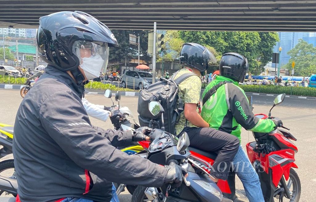 Pengendara sepeda motor di Jakarta Pusat memakai sarung tangan dan masker untuk melindungi diri dari paparan sinar matahari, Selasa (10/10/2023).