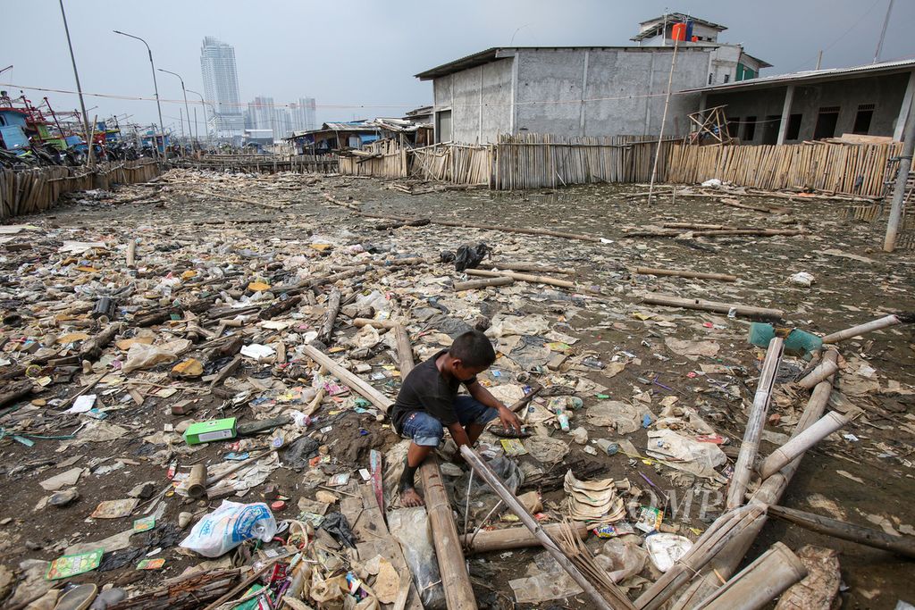 Seorang anak bermain di tengah hamparan sampah di kawasan Muara Angke, Jakarta, Senin (1/7/2024). Badan Pusat Statistik DKI Jakarta mencatat persentase penduduk miskin pada Maret 2024 turun 0,14 persen terhadap Maret 2023 yang sebesar 4,44 persen menjadi 4,30 persen. 