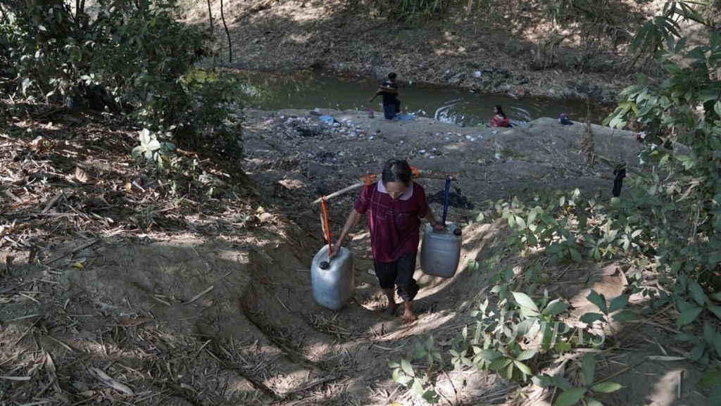 Ajat (50) mencari air bersih menggunakan jeriken di Kali Cihoe, Desa Ridogalih, Kecamatan Cibarusah, Kabupaten Bekasi, Jawa Barat, pertengahan Juli 2019.