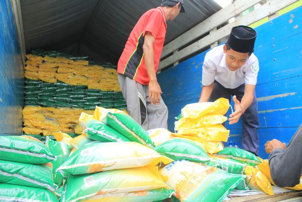 Petugas menurunkan beras dari truk saat operasi pasar murah di Pondok Pesantren Gedongan, Desa Ender, Kecamatan Pangenan, Kabupaten Cirebon, Jawa Barat, Senin (19/2/2024).