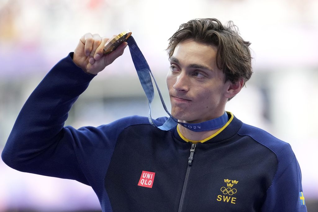 Atlet Swedia, Armand Duplantis, memegang medali emas yang diraihnya dari nomor lompat galah putra Olimpiade Paris 2024, Selasa (6/8/2024), di Paris, Perancis. Duplantis memecahkan rekor dunia dengan lompatan 6,25 meter.