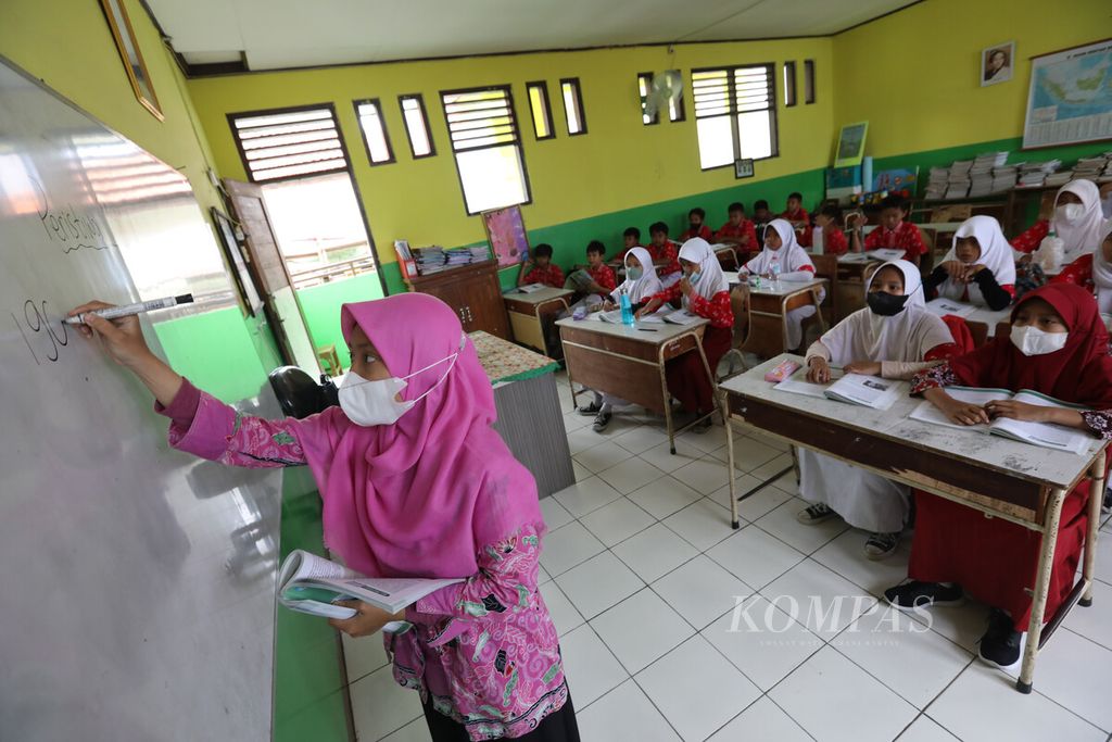 Layla Khoirrini, guru honorer yang bertugas di SDN Bintara Jaya 1, Kota Bekasi, Jawa Barat, mengajar di depan kelas, Kamis (24/11/2022). Hingga November 2022, di atas kertas lebih dari 421.000 guru mendapat formasi. Namun, tetap banyak masalah yang dihadapi para guru, mulai dari belum diangkat oleh pemda hingga gaji yang belum dibayar. 