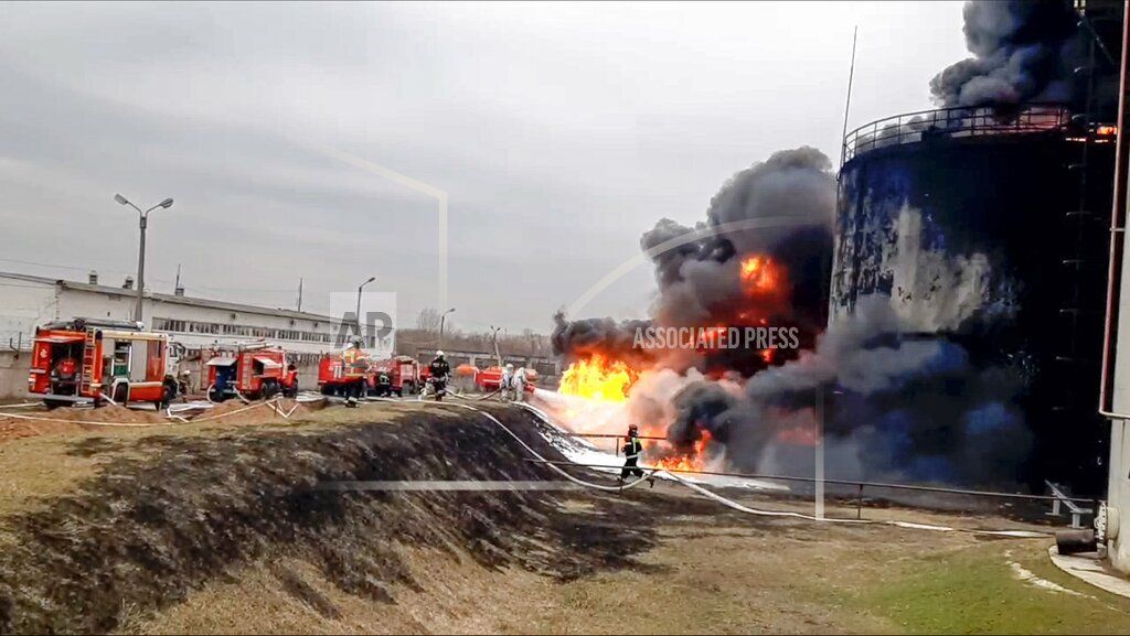 Dalam foto yang dirilis Pemerintah Rusia, pemadam kebakaran berupaya memadamkan api di kilang minyak di wilayah Belgorod, Rusia, Kamis (1/4/2023). Rusia menuduh Ukraina menyerang kilang melalui serangan helikopter tempur.