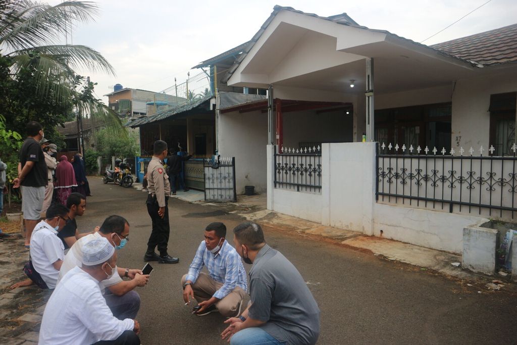 Suasana halaman depan rumah PW (69), warga yang meninggal di Kompleks Bumi Pelita A7 Nomor 5, RT 001 RW 009, Pondok Cabe Udik, Pamulang, Tangerang Selatan, Jumat (25/11/2022). Terlihat warga dan polisi sedang menunggu ambulans.
