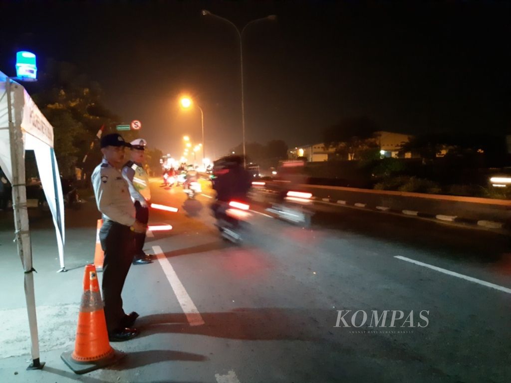 Polisi mengatur lalu lintas kendaraan di jalur pantura, Kabupaten Bekasi, Jawa Barat, Rabu (13/6/2018) malam.
