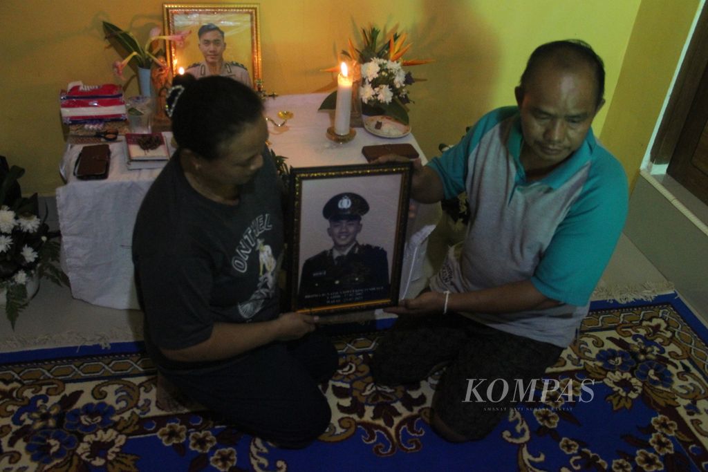 Y Pandi (51), ayah korban, dan Inosensia Antonia Tarigas (49), ibunda korban, memegang foto Bripda Ignatius Dwi Frisco Sirage, Kamis (27/7/2023), di rumah mereka di Melawi, Kalimantan Barat.