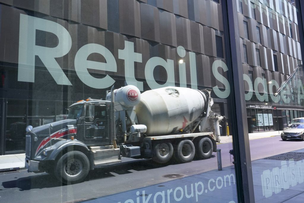 Sebuah truk pengaduk semen terpantul di jendela kaca yang bertuliskan iklan penyewaan ruang di sebuah gedung yang tengah diperbaiki di Essex Crossing di Lower East Side Manhattan, Kamis (4/8/2022).