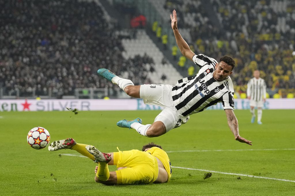 Pemain Juventus, Danilo, ditekel oleh pemain Villarreal, Pau Torres, dalam pertandingan babak 16 besar putaran kedua Liga Champions Eropa antara Juventus dan Villarreal, Kamis (17/3/2022) dini hari WIB, di Stadion Juventus Arena. Villarreal menang 3-0.