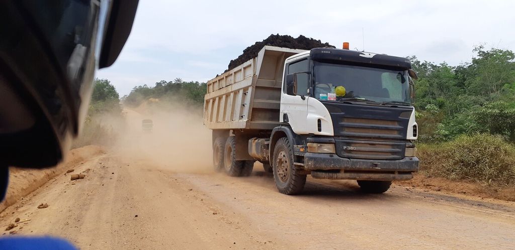 Pengangkutan hasil tambang batu bara di Koto Boyo, Kecamatan Batin XXIV, Batanghari, Jambi, Senin (18/10/2021). Pekatnya debu yang berterbangan di udara menghalangi jarak pandang dan mengancam keselamatan pengguna jalan lainnya.