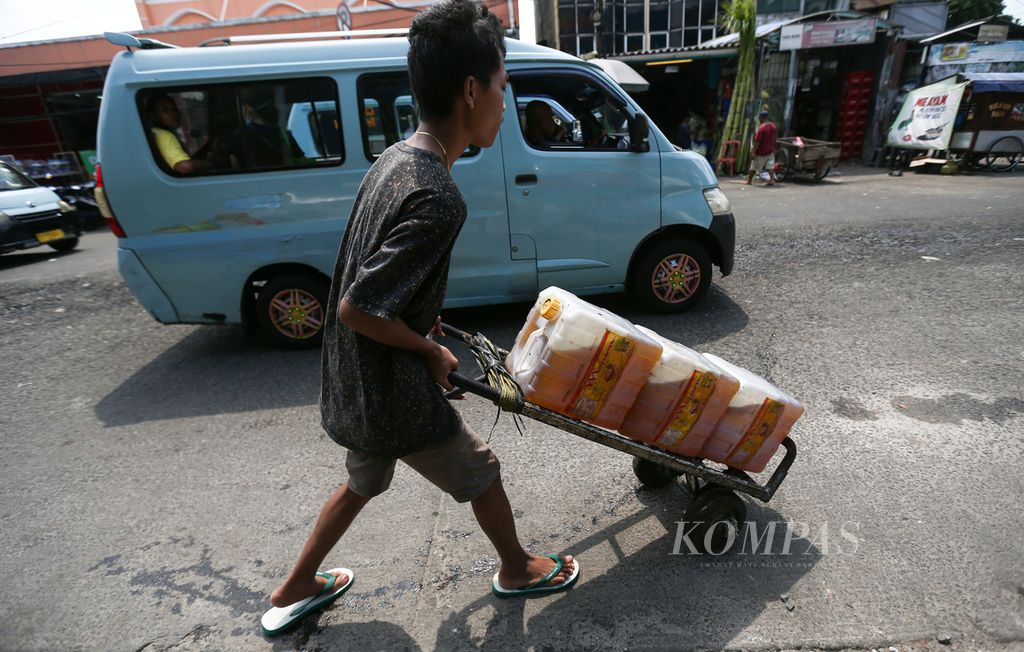 Pedagang membawa jeriken berisi minyak goreng curah yang dibeli dalam operasi pasar minyak goreng curah bersubsidi di Pasar Kebayoran Lama, Jakarta Selatan, Senin (23/5/2022).