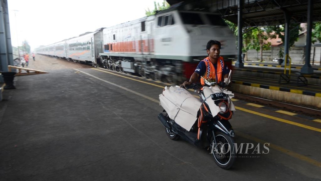 Pekerja mendorong sepeda motor yang baru saja diturunkan dari gerbong kereta Angkutan Motor Gratis (Motis) di Stasiun Purwosari, Solo, Jawa Tengah, Selasa (28/5/2019). 