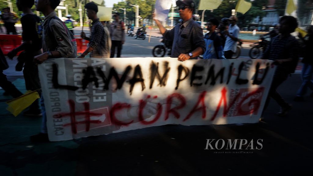Spanduk yang dibawa massa dari Pergerakan Mahasiswa Islam Indonesia (PMII) saat tiba di kawasan Patung Arjuna Wijaya atau Patung Kuda, Jakarta, untuk menggelar aksi memprotes sikap Presiden Joko Widodo, Senin (12/2/2024). 