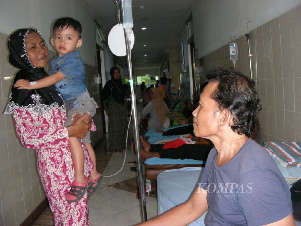 Bintang Langit Ramadhan (4) yang terkena demam berdarah digendong pihak keluarga. Anak-anak yang daya tahannya lemah rentan terhadap penyakit yang disebabkan nyamuk <i>Aedes aegypti</i> itu. Sejumlah pasien anak yang menderita demam berdarah di Rumah Sakit Umum Daerah Dr Harjono Ponorogo, Jawa Timur, Kamis (31/1/2019), dirawat di lorong. 