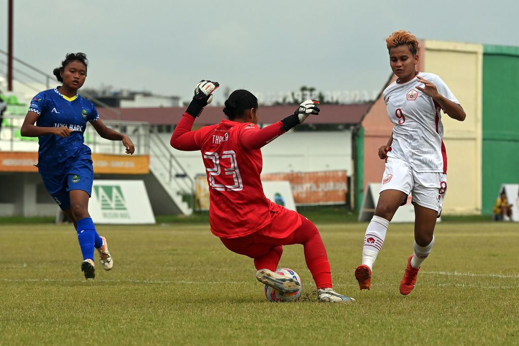 Kiper Jawa Barat, Adinda Amalia Putri (tengah), menyelamatkan gawangnya dari ancaman pemain DKI Jakarta, Carla Bio (kanan), dalam final sepak bola putri PON Aceh-Sumut di Stadion Mini, Deli Serdang, Sumatera Utara, Sabtu (14/9/2024). 