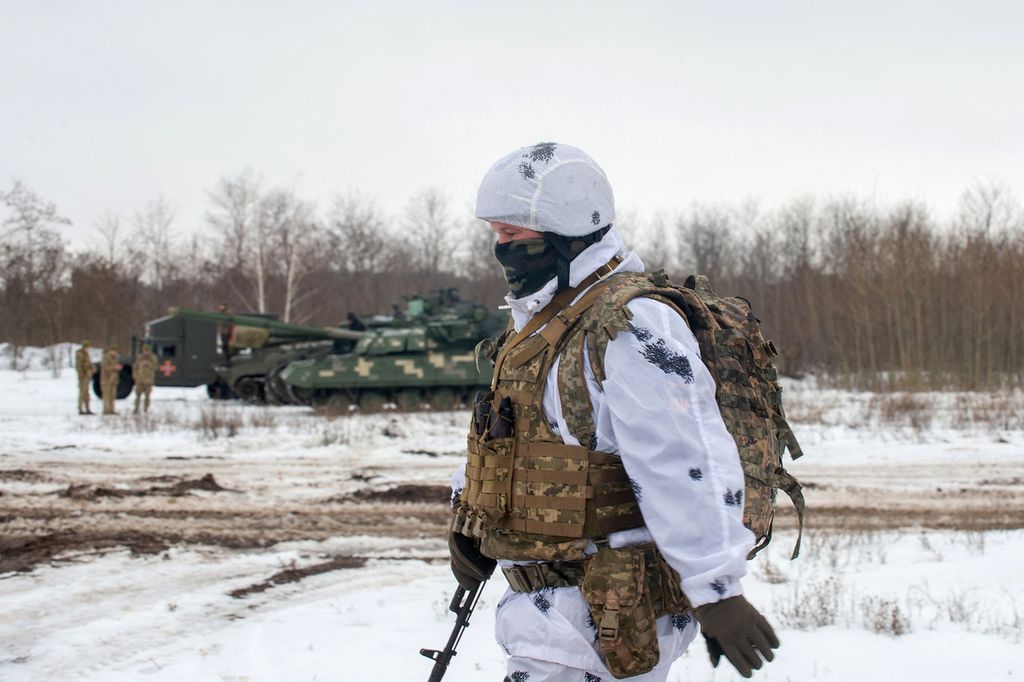 Seorang prajurit Pasukan Militer Ukraina dari brigade mekanik ke-92 berjalan di lapangan selama latihan tempur di dekat kota Chuguev, wilayah Kharkiv, Ukraina, Kamis (10/2/2022). Latihan tempur tersebut menyusul ketegangan antara Ukraina dan Rusia.