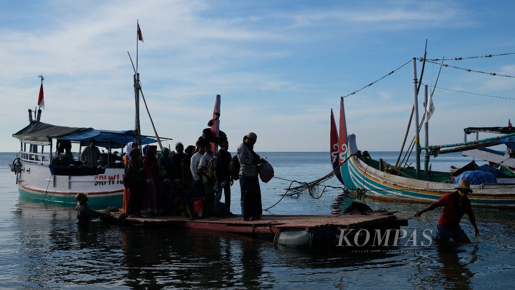 Penumpang menaiki rakit untuk menjangkau daratan setelah perahu tiba di Pulau Gili Iyang, Sumenep, Madura, Jawa Timur, Jumat (13/4/2018).