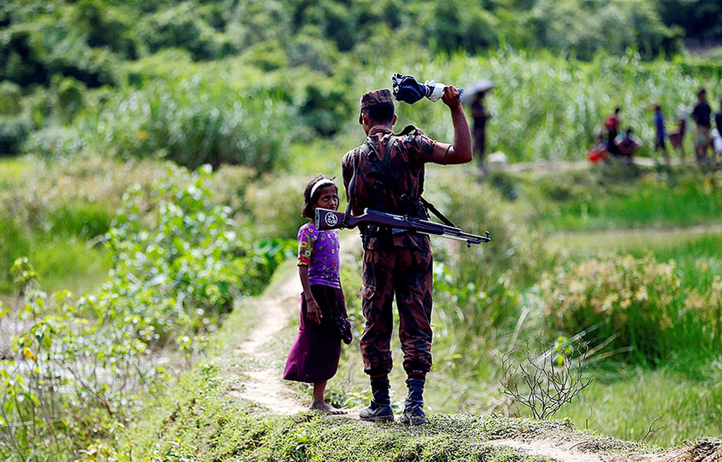 Anggota  Pasukan Perbatasan Banglades (BGB) melarang seorang anak perempuan Rohingya untuk masuk ke wilayah Banglades di pintu pelintasan Ghumdhum di  Cox\'s Bazar, Banglades, Minggu (27/8). 