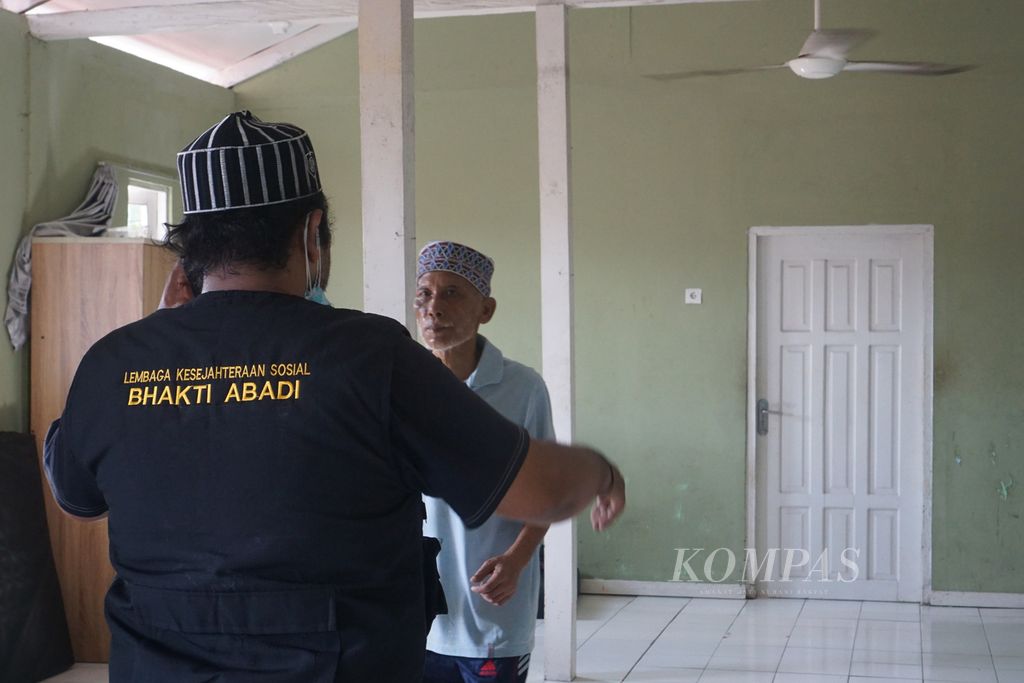 Joko Sumitro (39) menenangkan penghuni panti pria di salah satu dipan Panti Bhakti Abadi Kota Balikpapan, Kalimantan Timur, Kamis (5/9/2024).