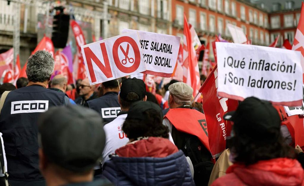 Para pengunjuk rasa membawa beragam poster, antara lain, bertuliskan pesan dalam bahasa Spanyol yang berarti "Inflasi apa? Mereka maling" dalam demonstrasi serikat pekerja menuntut kenaikan upah buruh di Lapangan Plaza Mayor, Madrid, Spanyol, 3 November 2022. 