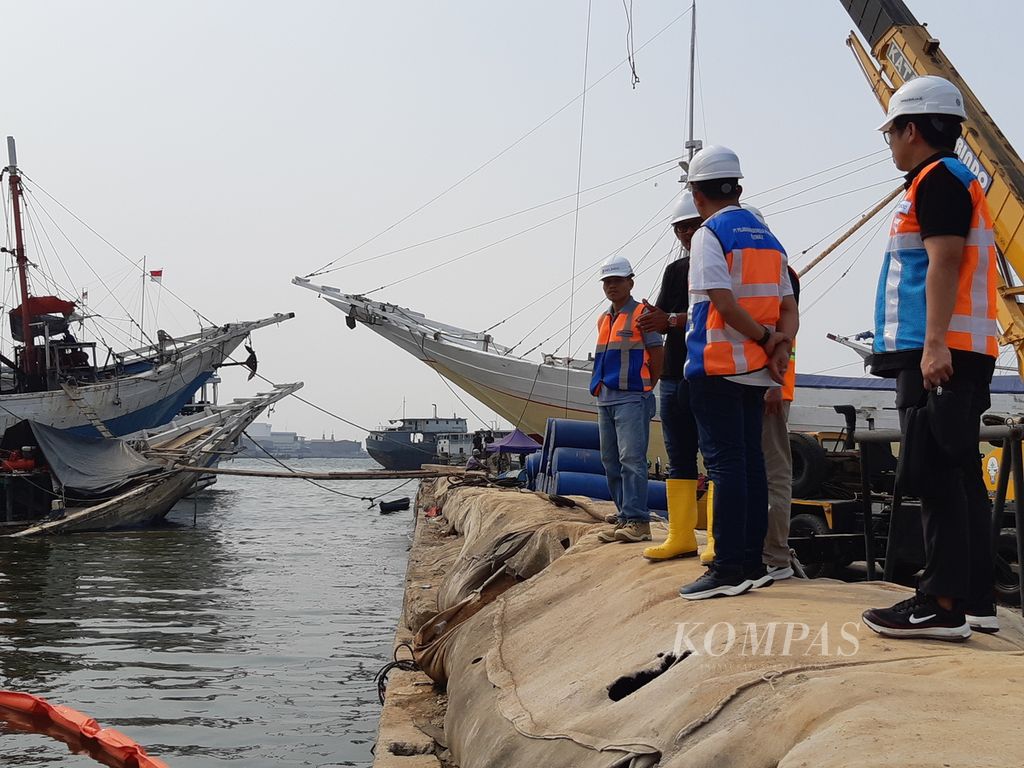 Sejumlah pejabat PT Pelindo Regional 2 Pelabuhan Sunda Kelapa meninjau proses evakuasi bangkai kapal yang menghalangi akses masuk-keluar pinisi di Pelabuhan Sunda Kelapa, Jakarta Utara, Minggu (16/7/2023) sore.