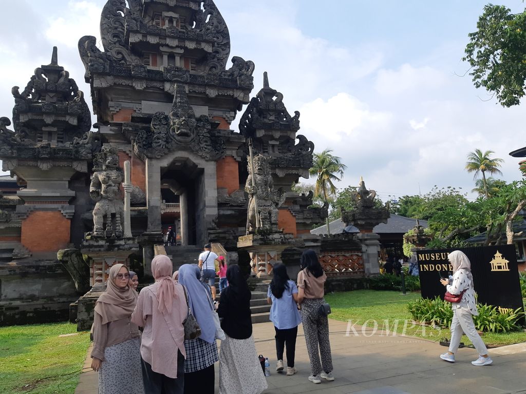 Sejumlah pengunjung berfoto di pintu masuk Museum Indonesia yang berada di Taman Mini Indonesia Indah (TMII), Jakarta Timur, Kamis (11/4/2024). Kunjungan wisatawan ke TMII melonjak signifikan pada libur Lebaran kali ini.