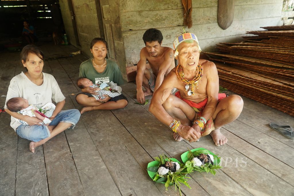 Sikerei, ahli pengobatan dan pemimpin ritual suku Mentawai, membacakan mantra dengan hidangan <i>subbet</i>, makanan karbohidrat dari umbi keladi rebus tumbuk, dan lauk sup kelelawar yang telah ditambahkan dengan berbagai jenis daun dalam ritual pemberkatan bayi di pedalaman Pulau Siberut di Dusun Salappa, Desa Muntei, Kecamatan Siberut Selatan, Kepulauan Mentawai, Sumatera Barat, Selasa (26/9/2023). Ritual diakhiri dengan memakan hidangan pangan lokal Mentawai. Pangan lokal menjadi salah satu elemen kunci dalam berbagai ritual adat masyarakat suku Mentawai. 