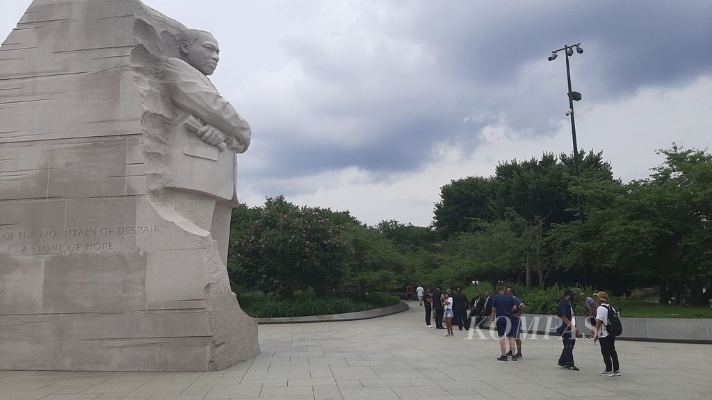 Pengunjung berfoto di depan patung Martin Luther King Jr di Washington DC, Amerika Serikat, 18 Juli 2022