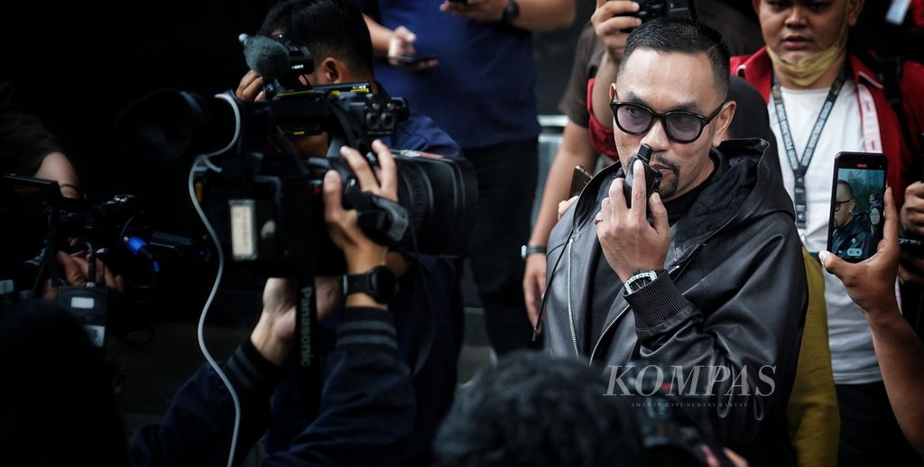 Bendahara Umum Partai Nasdem Ahmad Sahroni menggunakan radio panggil untuk minta dijemput sambil berjalan keluar meninggalkan Kantor Komisi Pemberantasan Korupsi, Jakarta, setelah memenuhi panggilan pemeriksaan, Jumat (22/3/2024).