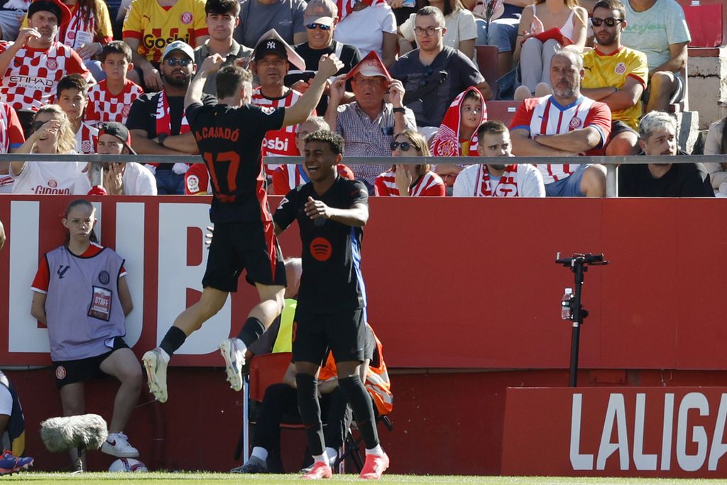 Penyerang Barcelona, Lamine Yamal (kanan), merayakan gol ke gawang Girona pada laga Liga Spanyol di Girona, Minggu (15/9/2024). Barca menang dengan skor 4-1. 