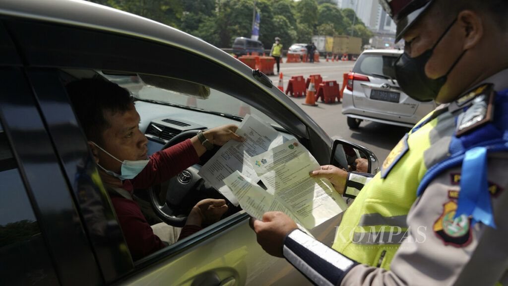 Polisi memeriksa surat kelengkapan dokumen dalam penyekatan arus mudik kendaraan di Jalan Tol Cikampek KM 31, Cikarang Barat, Kabupaten Bekasi, Jawa Barat, Kamis (6/5/2021). Penyekatan arus lalu lintas di titik-titik mudik pada hari pertama larangan mudik, Kamis (6/5/2021), diterapkan dengan tegas oleh pemerintah melalui Kementerian Perhubungan dan kepolisian. Koordinasi antarsejumlah pihak mesti ditingkatkan untuk mencegah warga nekat mudik dengan melakukan berbagai cara. Polisi mengerahkan 155.000 personel gabungan untuk mengawal larangan mudik.