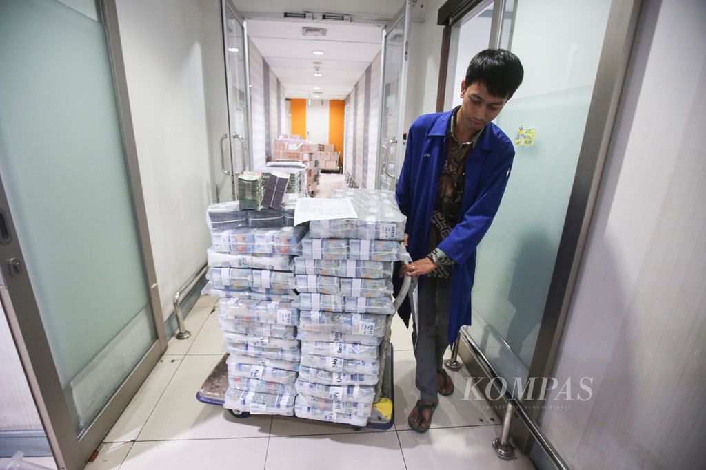 Officers prepare rupiah currency to be sent to branch offices of Bank Mandiri Cash Pooling in Jakarta, Monday (11/12/2023).