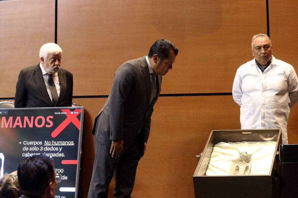 The photo released by the press office of the Mexican Congress shows a member of Congress, Sergio Gutierrez (left), looking at the body claimed to be an extraterrestrial creature exhibited at the Mexican Congress in Mexico City on September 12, 2023. Two extraterrestrial creature fossils were displayed in a public audience at the Mexican Congress.