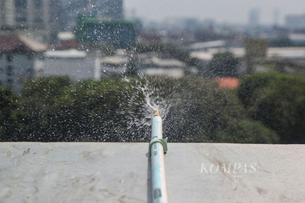 Partikel air keluar dari <i>water sprayer</i> di atas Kantor Wali Kota Jakarta Pusat, Selasa (5/8/2023). Berdasarkan hasil riset, upaya penyemprotan air dari ketinggian dapat menurunkan kadar PM 2,5 di sekitar area uji.