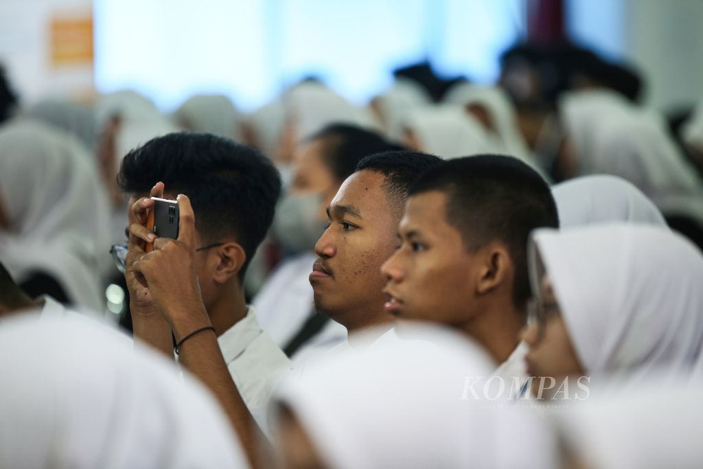 Pelajar mendokumentasikan materi terkait pinjaman <i>online</i> atau pinjol dalam kegiatan edukasi keuangan bagi pelajar tingkat SMA/sederajat di Auditorium Indonesia Banking School, Jakarta Selatan, Senin (22/01/2024).