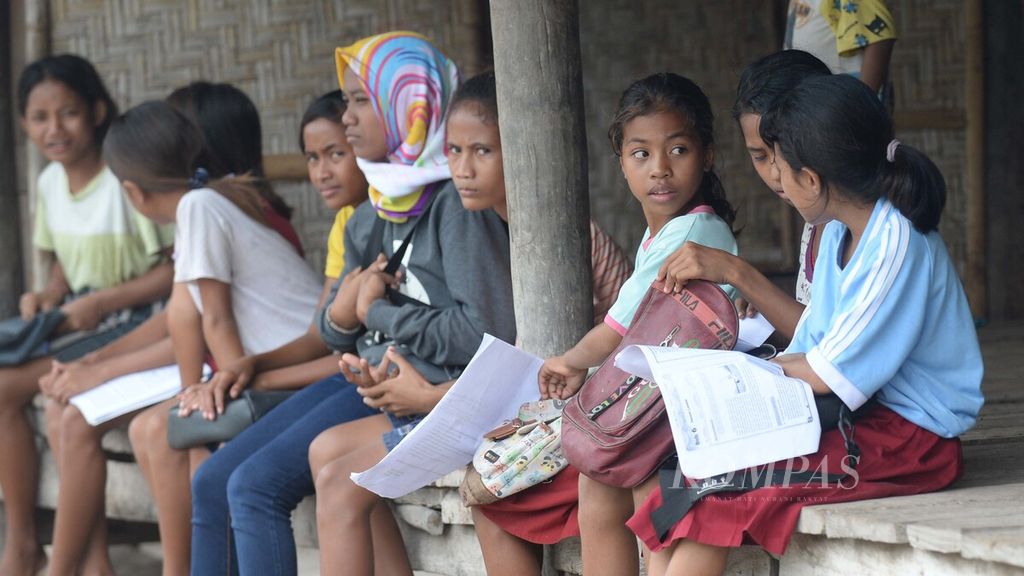 Para murid SD Negeri Watumbaka, Kecamatan Pandawai, Kabupaten Sumba Timur, Nusa Tenggara Timur, membaca buku saat menunggu kedatangan guru mereka di rumah warga di Desa Watumbaka, Pandawai, Sumba Timur, Rabu (3/2/2021).