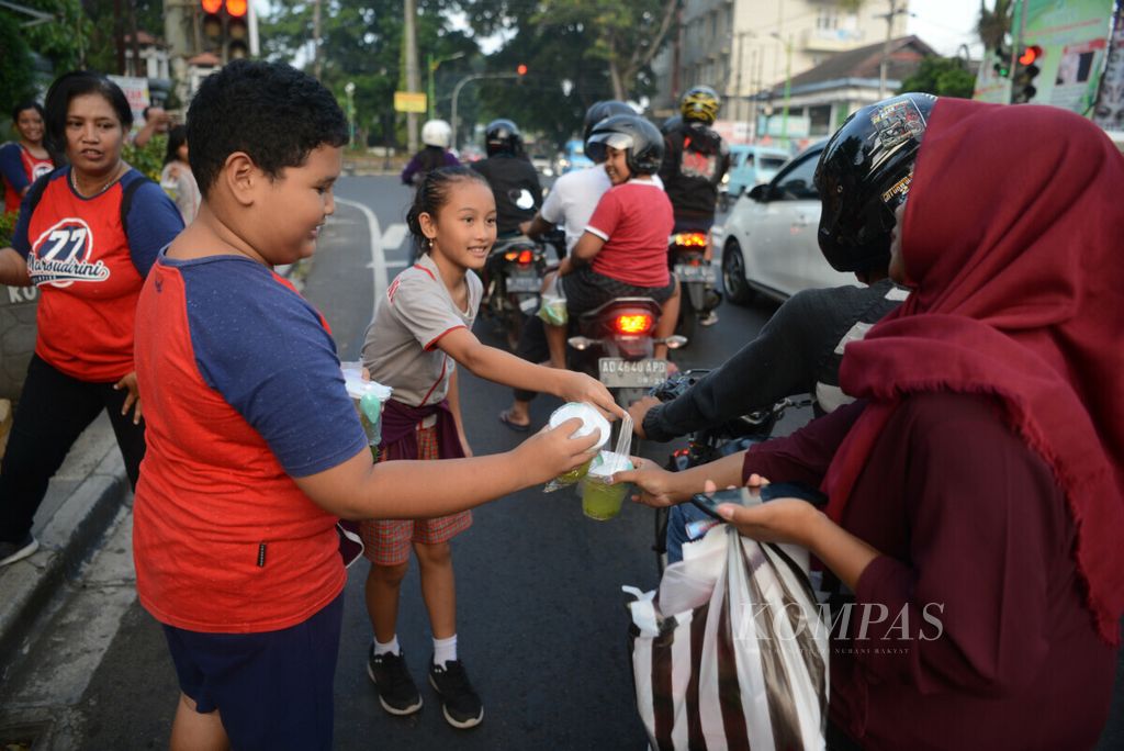 Murid SD Santa Theresia Marsudirini 77 membagikan takjil gratis kepada pengguna jalan di Jalan Diponegoro, Kota Salatiga, Jawa Tengah, Rabu (29/5/2019). Selain sebagai wujud semangat berbagi, kegiatan ini juga untuk mengajarkan sikap cinta kasih dan peduli kepada sesama.