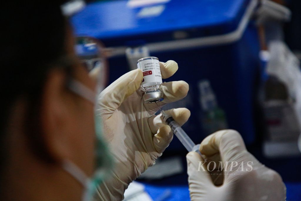 Petugas medis mempersiapkan vaksin <i>booster </i>atau penguat di gerai vaksin presisi yang digelar di Masjid Al-Ikhlas, Larangan Selatan, Larangan, Kota Tangerang, Banten, Sabtu (9/4/2022) malam. Gerai vaksin presisi yang diadakan Polsek Ciledug itu menggunakan vaksin Astra Zeneca.